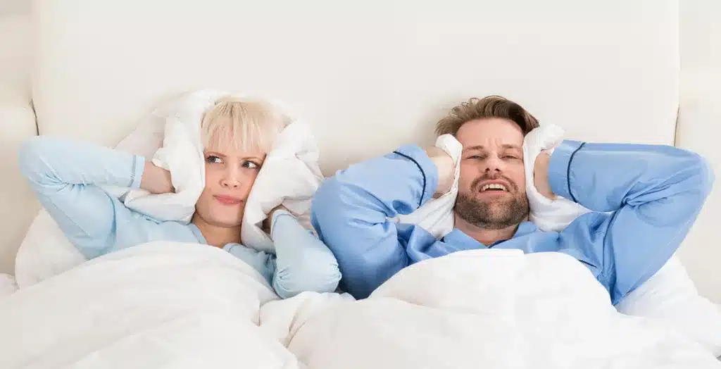 Man and Woman holding pillows over their head